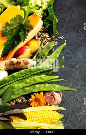 Different types of fresh fruits and vegetables on a dark background. Healthy food. Top view. Stock Photo