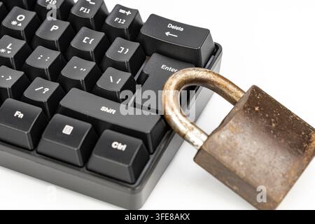 Rusty padlock beside a keyboard enter key, symbolizing cyber security, data protection, and online privacy concerns. Stock Photo