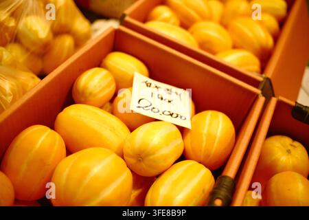 Fresh yellow melons displayed in boxes with price tags at a traditional market in Korea. Stock Photo