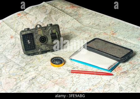 Wildlife trail camera with navigation tools on map Stock Photo