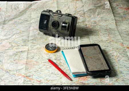 Trail camera and navigation tools on an exploration map Stock Photo