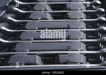 Side angle view shiny steel combination spanners stored in dedicated slots tool case Stock Photo