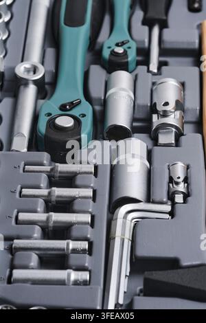 Vertical shot various hand tools including ratchets and hex sockets stored in plastic box Stock Photo