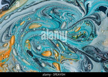 Dynamic turquoise and orange liquid swirl texture adorned with numerous shiny clear liquid droplets Stock Photo