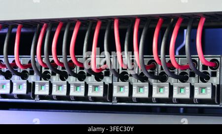 Close-up of server rack with neatly arranged cables. Black and white image shows network ports and connected cables. Server rack components visible in Stock Photo