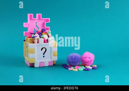 Happy couple full of love, cube with question mark filled with colorful hearts Stock Photo