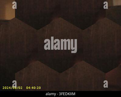 Dark brown hexagonal pattern backdrop with textured geometric honeycomb shapes, creating a modern abstract background. Stock Photo