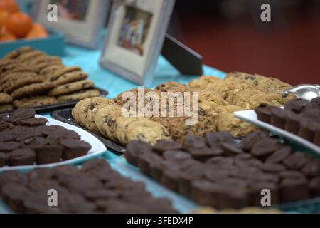 A delicious spread of freshly baked cookies, including chocolate chip and oatmeal, alongside chocolate brownies displayed on a dessert table set with Stock Photo