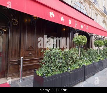 PARIS, FRANCE - SEPTEMBER 1, 2026 - Maxim's restaurant facade in Paris featuring a red awning, wooden doors, and green planters Stock Photo