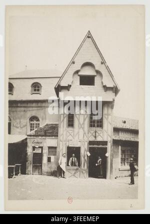 A street scene in the Bastille area of Paris, France, featuring timber-framed buildings with people standing in doorways, photographed in 1889 as part of a souvenir collection commemorating the 100th anniversary of the Bastille. Stock Photo
