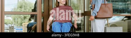 Header of Woman with Disability in Wheelchair Leaving Glass Building Stock Photo
