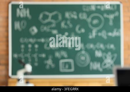 Science education and chemistry research, blurred chalkboard with chemical formulas and molecular structures in a laboratory classroom setting Stock Photo