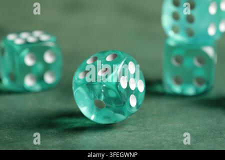 Turquoise game dices on green background Stock Photo