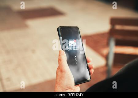 New message notification icon on smartphone screen. Mature woman holding phone with new message notification showing on screen. Stock Photo