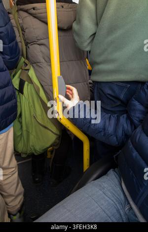 Disabled wheelchair / wheel chair user on a bus pressing the bell button to request leave / alight from the bus at the next stop. Twickenham, London. UK.(147) Stock Photo