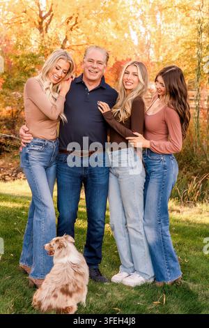 Happy family with dog posing for an autumn portrait Stock Photo