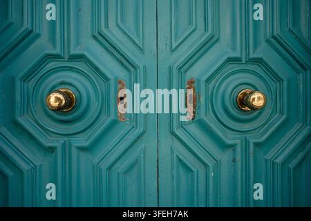 Symmetrical vintage teal doors with brass knobs Stock Photo
