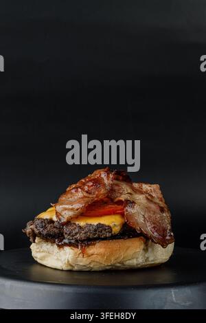 Delicious bacon cheeseburger on a dark plate Stock Photo