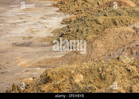 Large piles of excavated soil at a construction site with rough dirt ...
