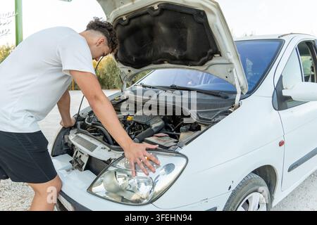 Young man experiencing car breakdown on roadside Stock Photo
