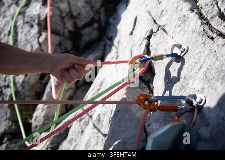 Improperly rigged multi pitch climbing belay station with a clove hitch on one anchor and no connection between two bolt anchors, illustrating anchor Stock Photo