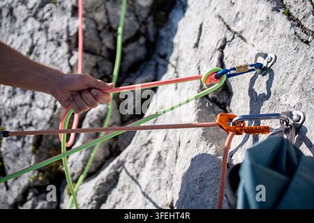 Improperly rigged multi pitch climbing belay station with a clove hitch on one anchor and no connection between two bolt anchors, illustrating anchor Stock Photo