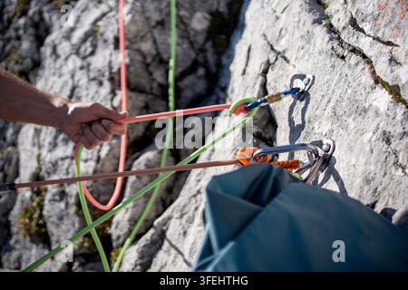 Improperly rigged multi pitch climbing belay station with a clove hitch on one anchor and no connection between two bolt anchors, illustrating anchor Stock Photo