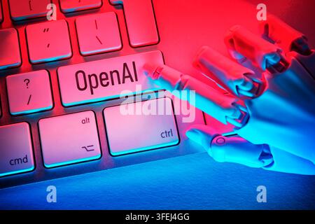 A robotic hand presses a key labeled "OpenAI" on a computer keyboard; photomontage Stock Photo
