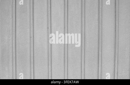 Close-up view of gray painted board and batten wood siding showing visible woodgrain, uneven paint coverage and wood texture Stock Photo