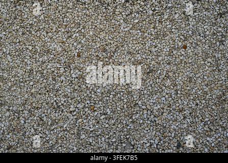 Decorative crushed stone aggregate wall surface in a horizontal close-up composition, showing embedded gravel with varied angular stone pieces Stock Photo