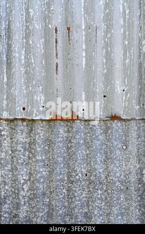 Overlapping corrugated galvanized metal panels with white mineral deposits, contrasting galvanized textures Stock Photo