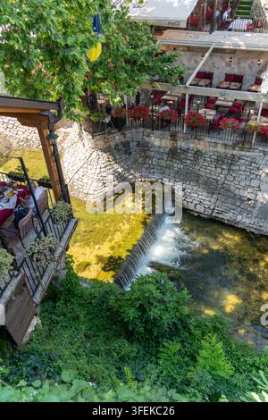 Mostar, Federation of Bosnia, Bosnia and Herzegovina - 22 June 2025: View of a restaurant terrace overlooking a small waterfall on the Radobolja river Stock Photo