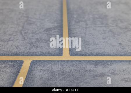 Close up view of installed blue ceramic floor tiles with beige grout lines Stock Photo
