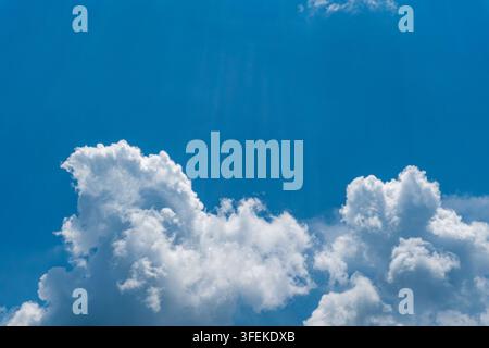 Bright blue sky with large billowing white cumulus clouds forming a dramatic natural cloudscape, with broad open space suitable for background Stock Photo