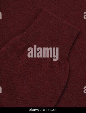 Close-up of the ribbed sleeve cuff and knitted fabric texture of a burgundy sweater photographed for apparel catalog. Stock Photo