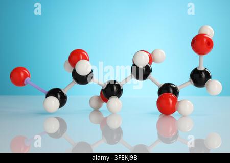 Chemical model of glucose molecule on white table against blue background, closeup Stock Photo
