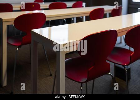 Empty red chairs and tables in modern classroom Stock Photo