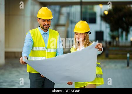 Engineers discussing blueprint for a construction project Stock Photo