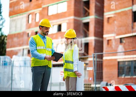 Construction engineers working on building site planning Stock Photo