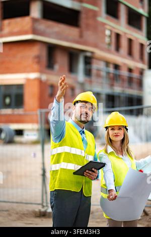 Construction engineers working on building site planning development Stock Photo
