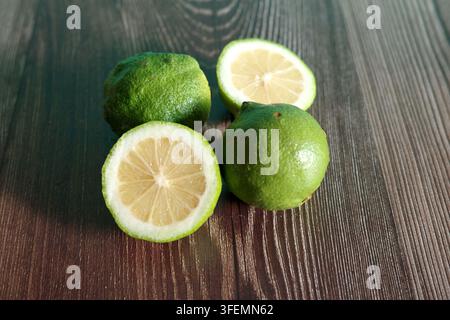 Fresh green limes on a dark wooden background Stock Photo