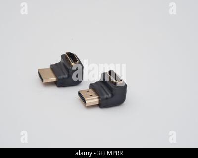 Two Black HDMI Right Angle Adapters - Two L-shaped HDMI male to female adapters in black plastic and gold-plated connectors, on a clean white backgrou Stock Photo