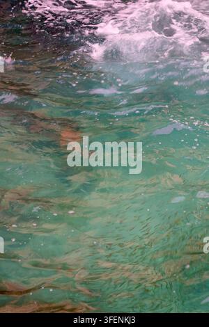 Crystal Clear Tropical Water Surface with Gentle Wave and Underwater Rock Texture Stock Photo