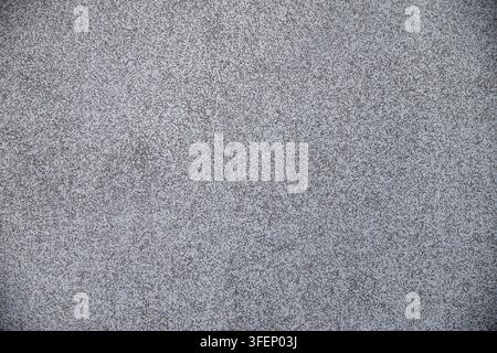 Close-up of rough speckled grey and brown textured wall surface with mottled aggregate finish. Stock Photo
