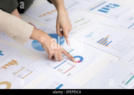 Close up two female financial analysts working with sales infographics Stock Photo