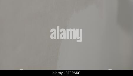 Slow motion worker applying putty on the wall Stock Photo