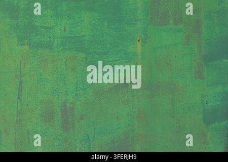 Close-up view of a textured green painted metal surface showing signs of aging. Brush strokes and rust spots add character to this abstract background. Stock Photo
