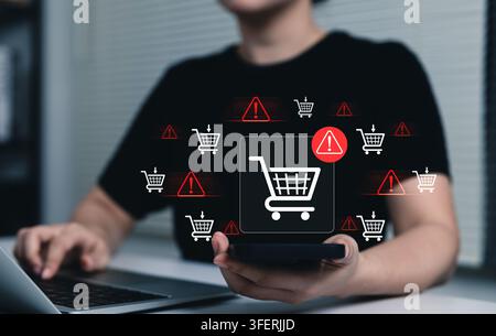 E-Commerce Warning and Shopping Cart Risk Concept. Woman using laptop and smartphone with shopping cart icons, online purchase issues, checkout risk, Stock Photo