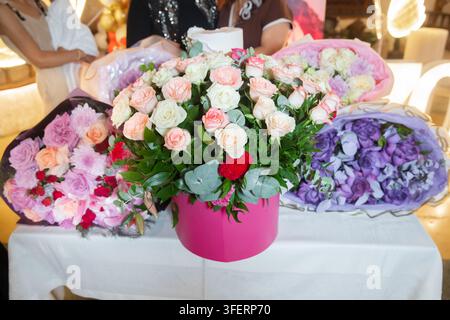 Gorgeous flower compositions on the table for birthday or anniversary gift. Beautiful luxurious bouquet of fresh pink and white roses in a round box Stock Photo