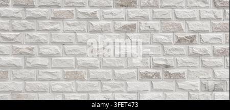 White brick wall displaying a natural rough stone texture and modern masonry pattern Stock Photo